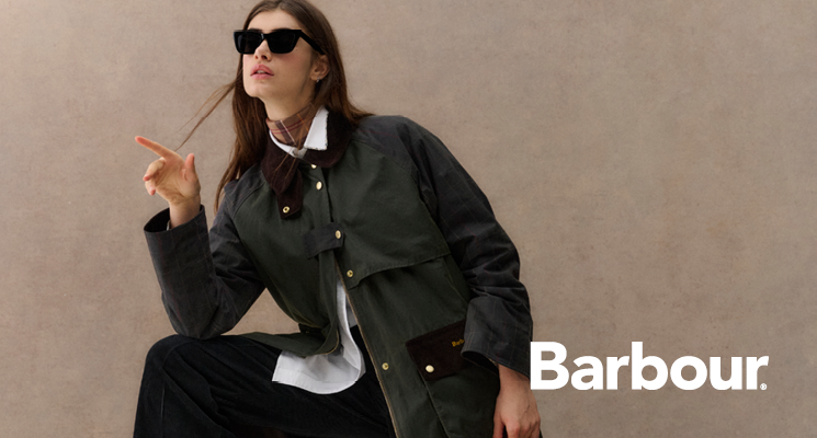 Sitzende Frau mit khakifarbener Jacke von Barbour