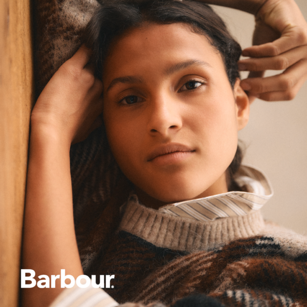 Frau mit kariertem Wollpullover in beige dunkelbraun von Barbour