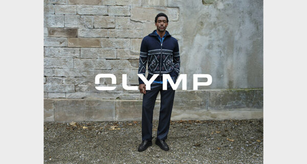Mann trägt Strickjacke in blau mit Streifen und Karos sowie dunkelblauer Stoffhose von Olymp