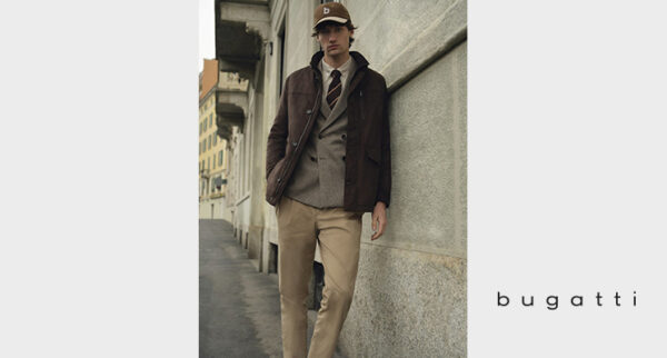 Mann mit Cap und dunkelbrauner Jacke, grauem Sakko, brau gestreifter Krawatte und beiger Hose von Bugatti