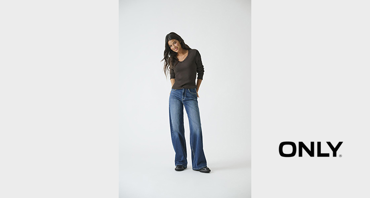 Frau mit braunem Pullover und blauer Jeans von Only