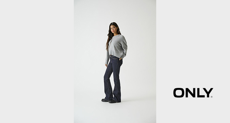 Frau mit grauem Pullover und blauer Jeans von Only