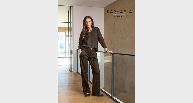 Stehende Frau an Geländer mit braunem Pullover und brauner Hose von Raphaela by BRAX