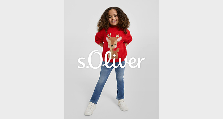 Mädchen in rotem Pullover mit Weihnachtsmotiv Reh und blauer Jeans von S Oliver
